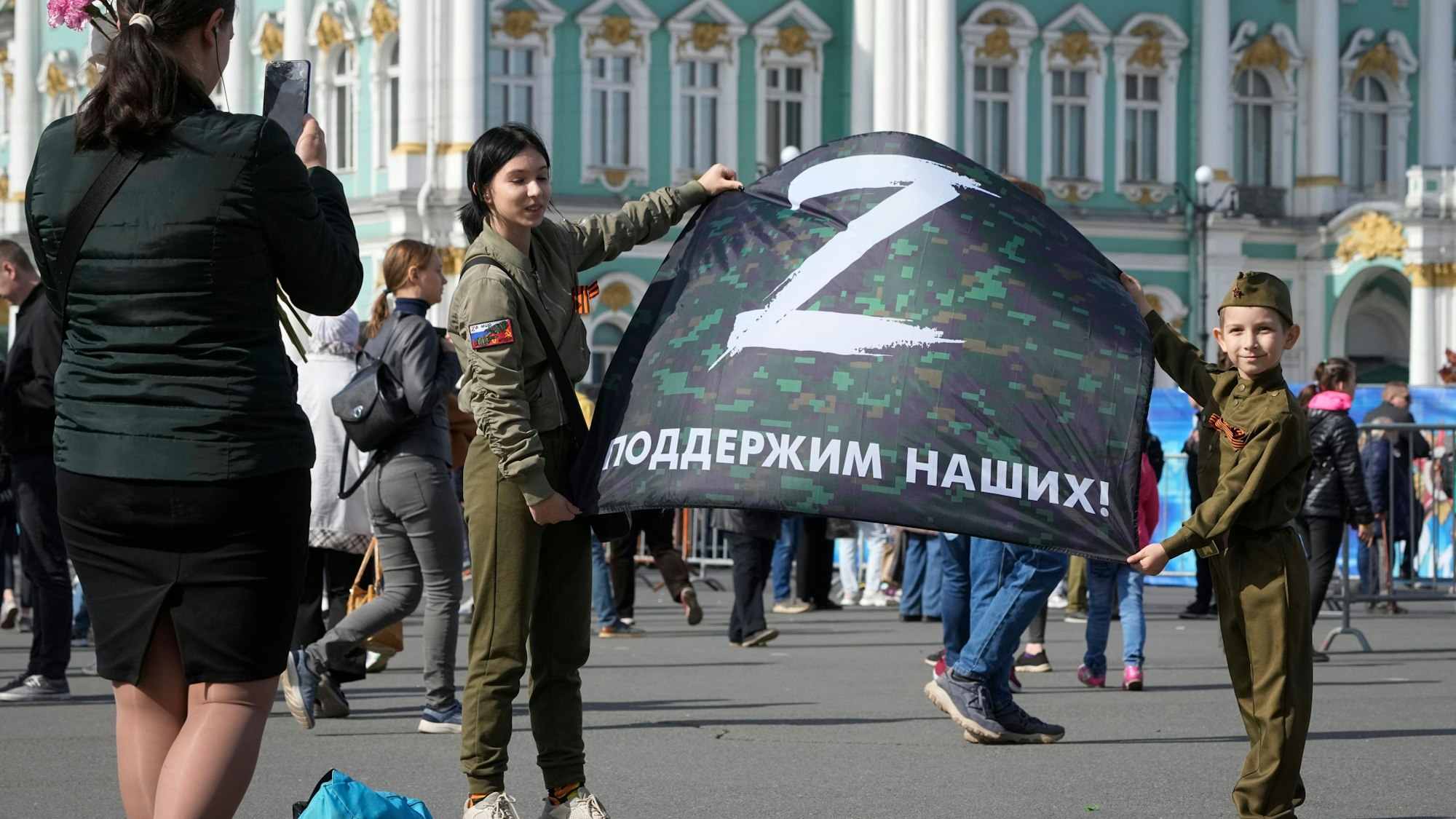 Zwei russische Kinder Kinder halten ein Banner, auf dem der Buchstabe Z, der zum Symbol für das russische Militär geworden ist, abgebildet ist