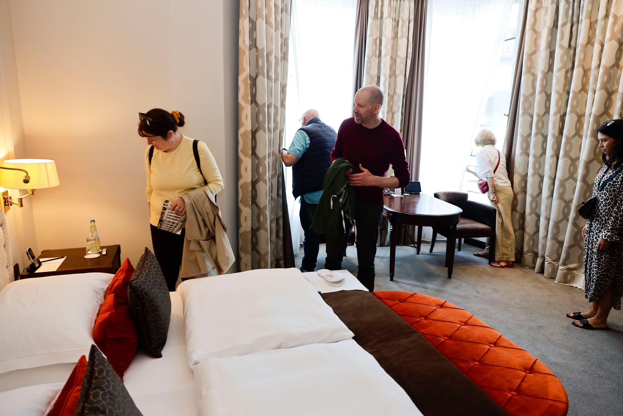 Besucher gehen durch ein Hotelzimmer.