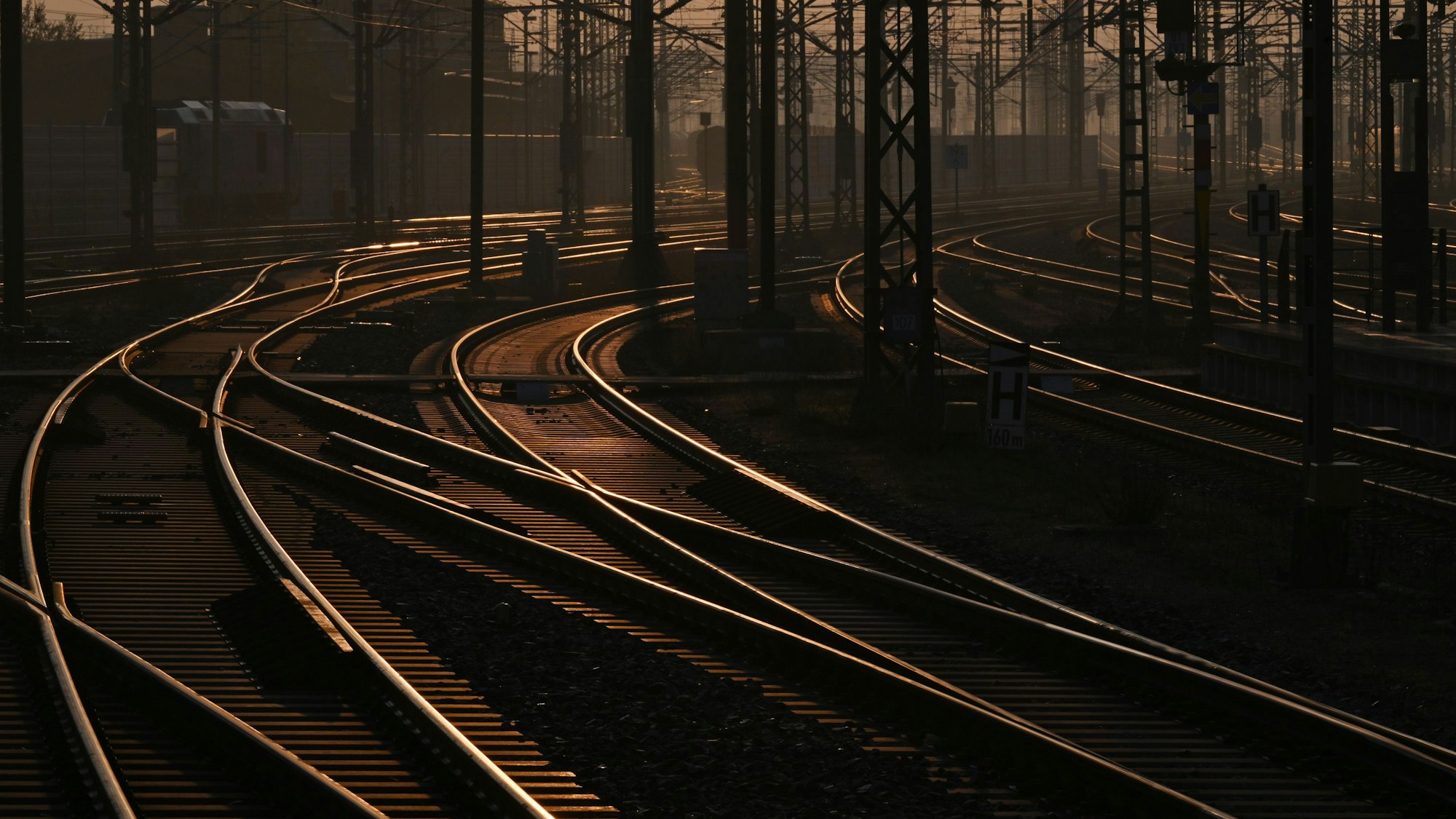 Die Sonne spiegelt sich auf leeren Gleisen. (Symbolbild)