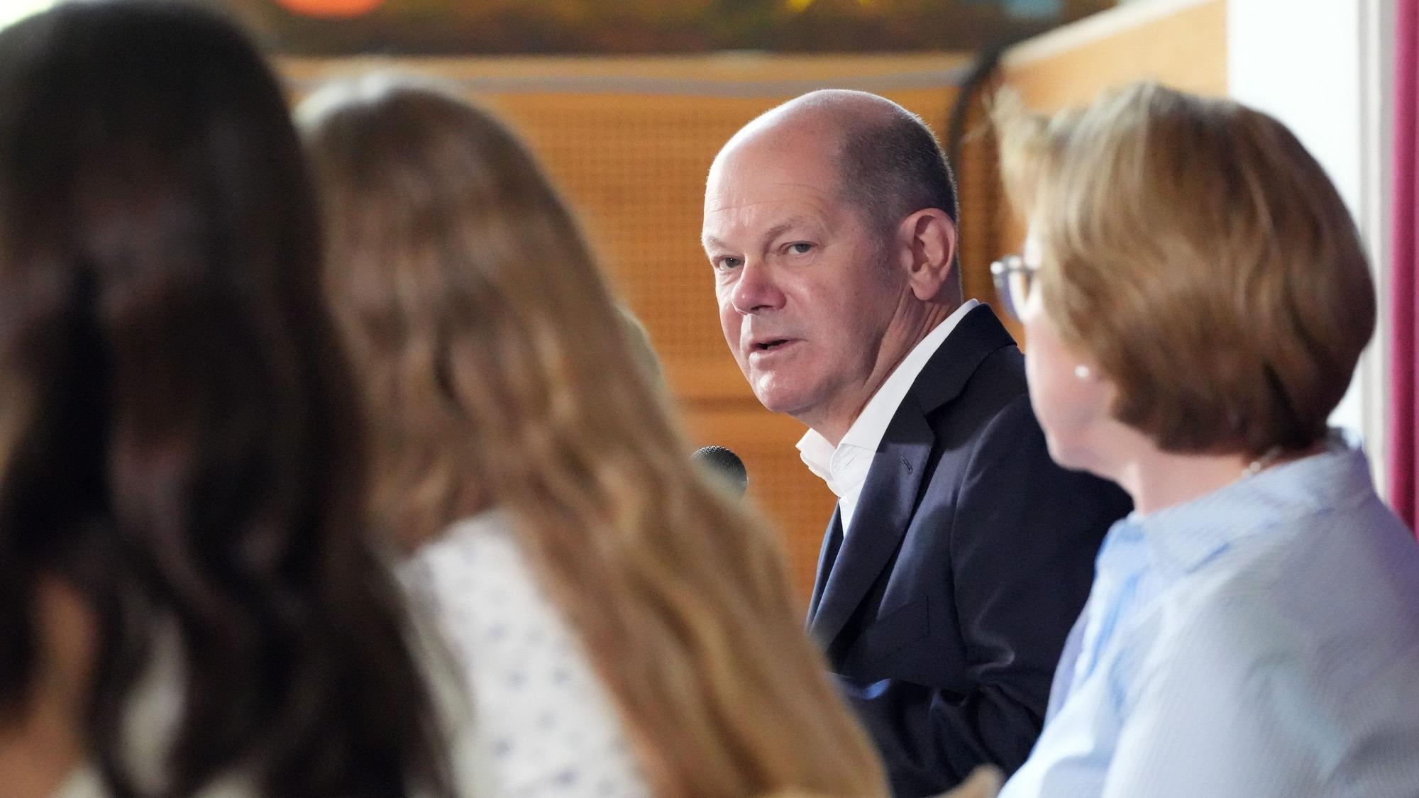Bundeskanzler Olaf Scholz (SPD) besucht anlässlich des EU-Projekttages die Eigenherd-Schule und beantwortet in der Mensa die Fragen der auf dem Podium sitzenden Schüler der sechsten Klassenstufe.