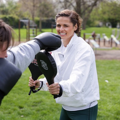 Zwei Frauen boxen im Park.