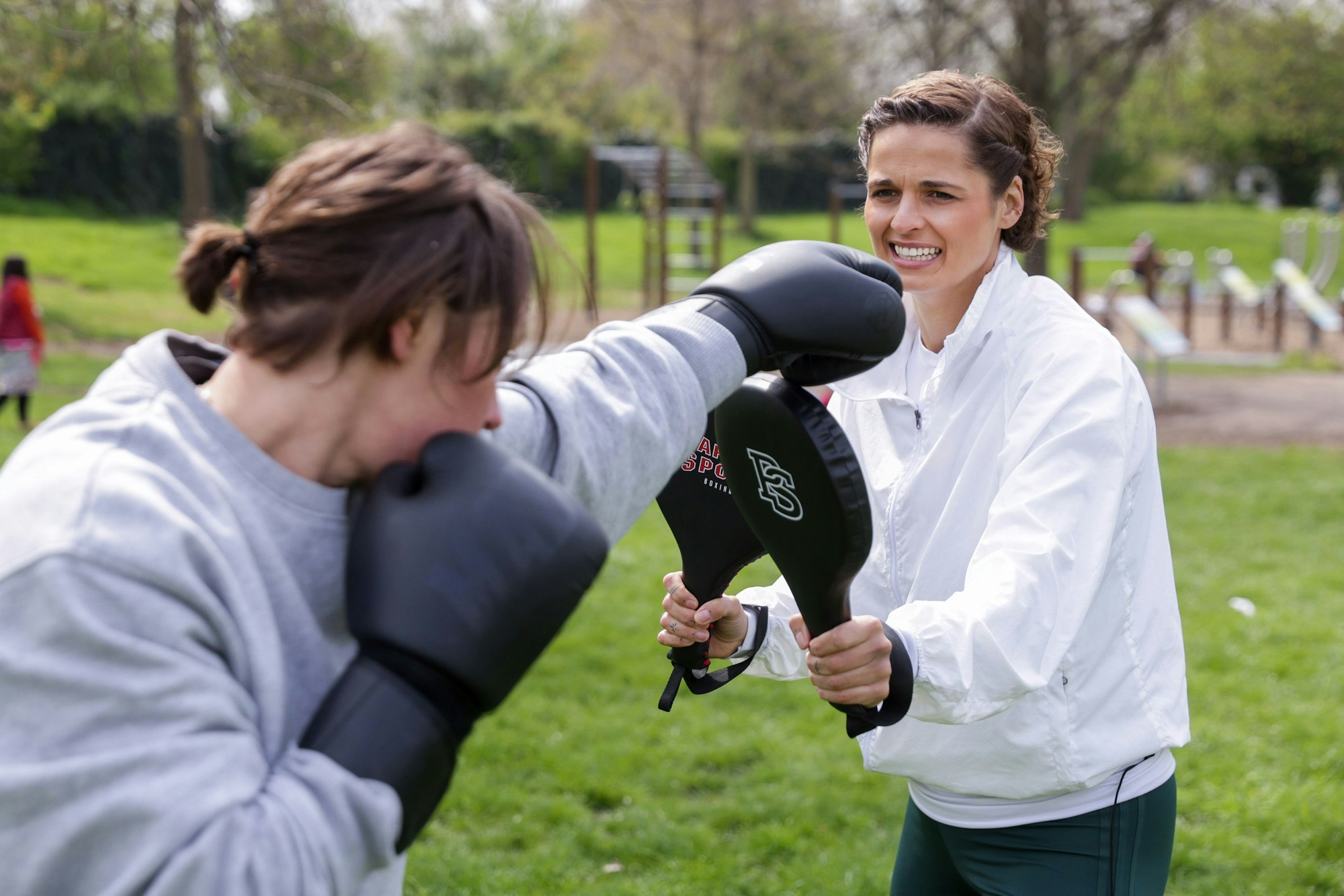 Zwei Frauen boxen im Park.