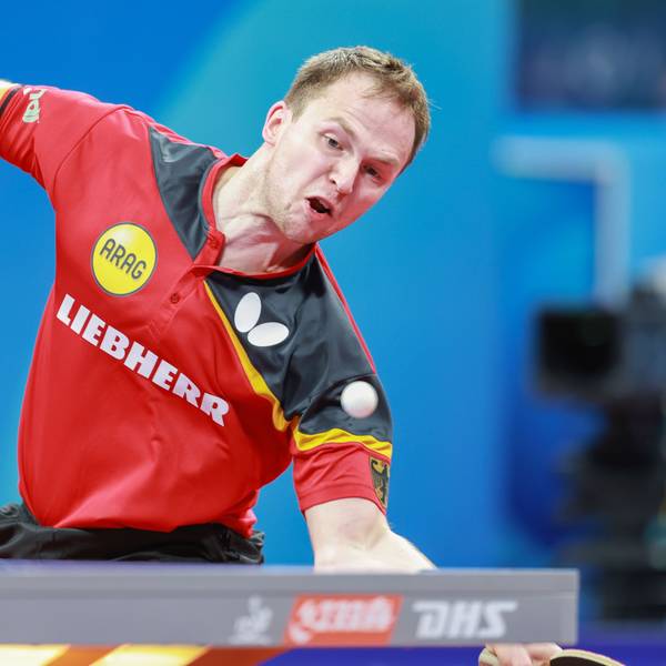 Im Bild ist ein Tischtennisspieler zu sehen, der gerade einen Ball annimmt.