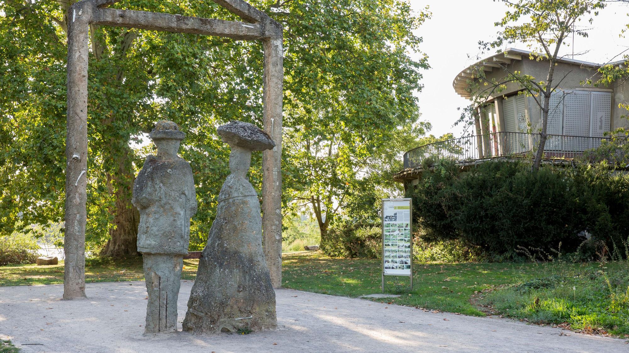zwei Skulpturen aus Stein stehen auf einem Weg