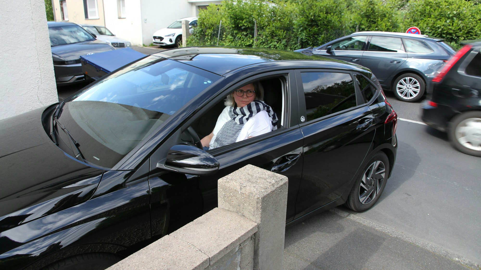 Karin Wollsiefen aus Wolsdorf fürchtet, das sie nicht mehr auf ihr Grundstück fahren kann, wenn die Stadt gegenüber einen Parkplatz ausweist