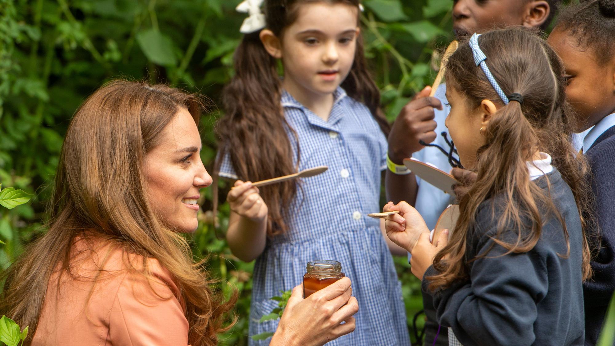 Catherine, Herzogin von Cambridge, gibt Kindern Honig zum Probieren, als sie das UrbanNature-Projekt im Natural History Museum am 22. Juni 2021 in London, England, besucht.