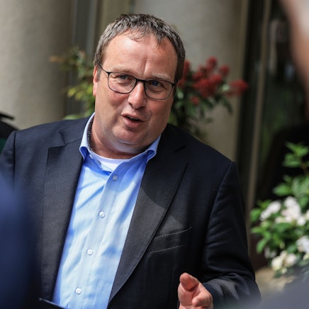 Oliver Krischer (Bündnis 90/Die Grünen), Minister für Umwelt, Naturschutz und Verkehr des Landes Nordrhein-Westfalen. Er trägt einen Anzug und ein blaues Hemd.