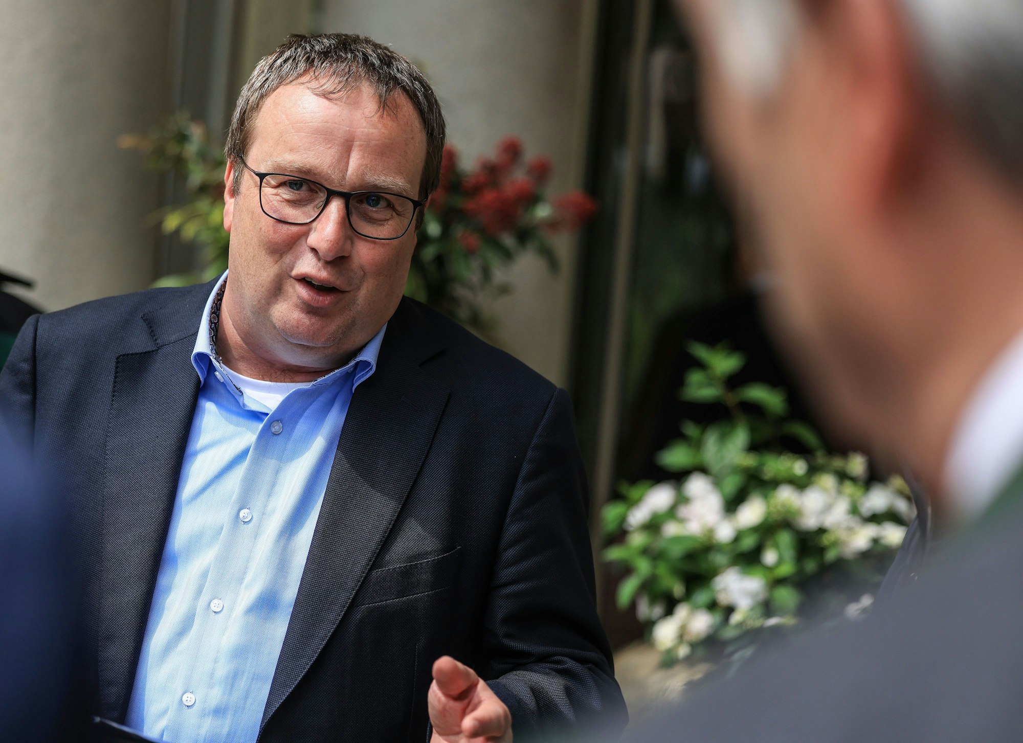 11.05.2023, Nordrhein-Westfalen, Königswinter: Oliver Krischer (Bündnis 90/Die Grünen), Minister für Umwelt, Naturschutz und Verkehr des Landes Nordrhein-Westfalen, spricht vor dem Tagungsort der Umweltministerkonferenz bei der Übergabe einer Resolution, in der eine stärkere Kontrolle der Wolfspopulation gefordert wurde, mit Vertretern verschiedener Landwirtschaftsverbände.