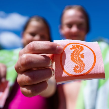 Zwei Mädchen halten ihre Seepferdchen-Abzeichen in den Händen.