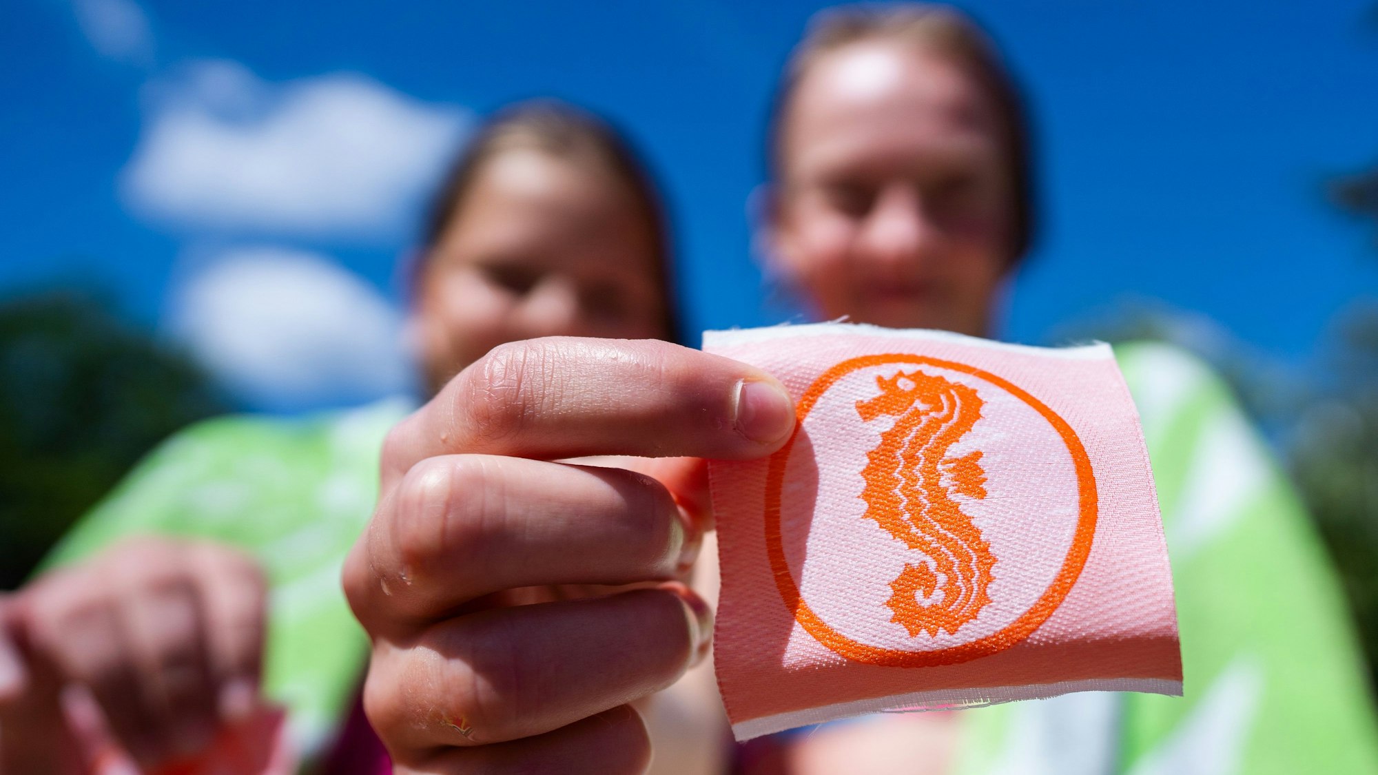 Zwei Mädchen halten ihre Seepferdchen-Abzeichen in den Händen.