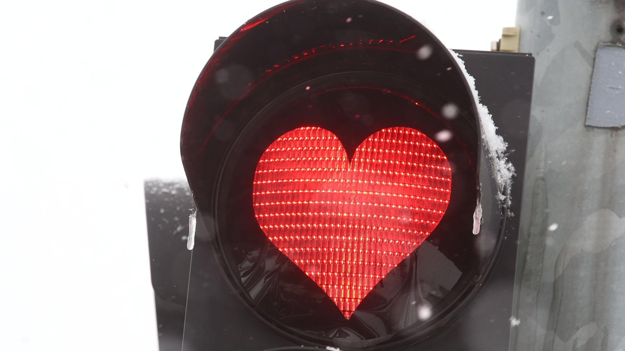 Ein rotes Herz leuchtet an einer Verkehrsampel, eigentlich zu einer Aktion am Valentinstag. Zu einem Fall aus Erfurt passt das Bild aber auch: Ein Paar hatte Sex in einem Auto, weil die rote Ampelphase zu lang war. (Symbolbild)