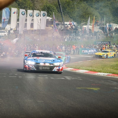 Ein Rennwagen fährt am Publikum vorbei.