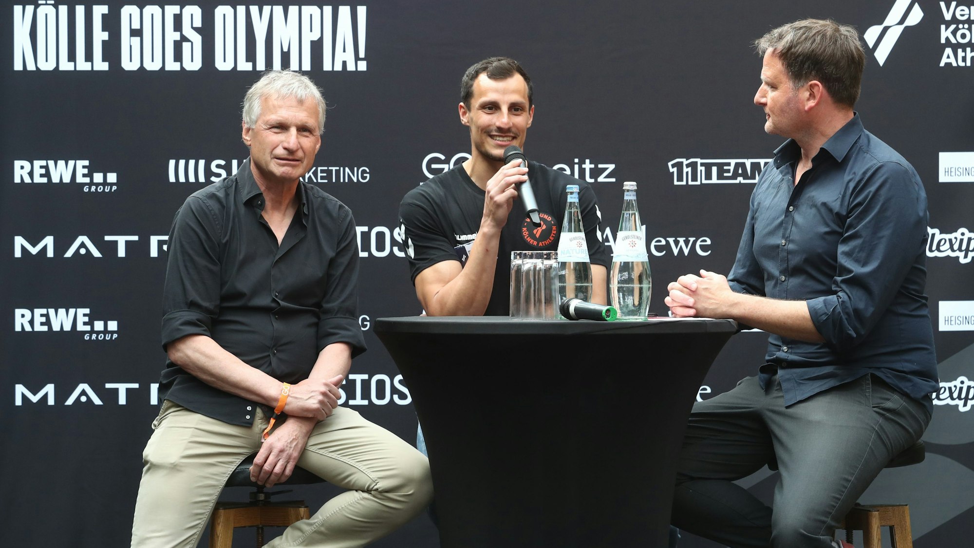 Michael Reschke, Timur Oruz und Thomas Wagner sind an einem Tisch im Gespräch.