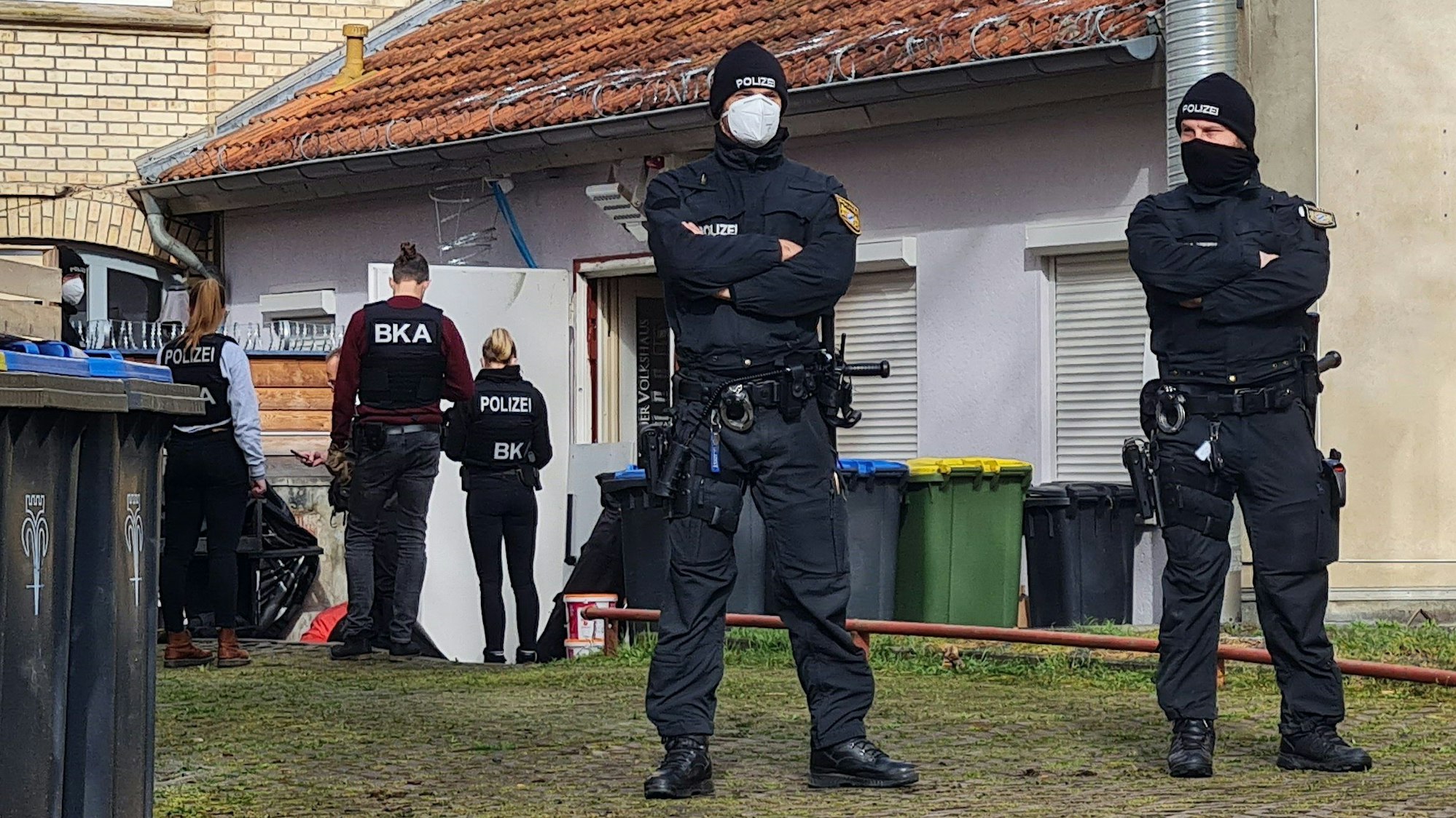 Polizisten sichern den Hintereingang eines Gebäudes: Die vier Gründer der rechtsextremistischen Terror-Gruppe Knockout 51 wurden verhaftet.