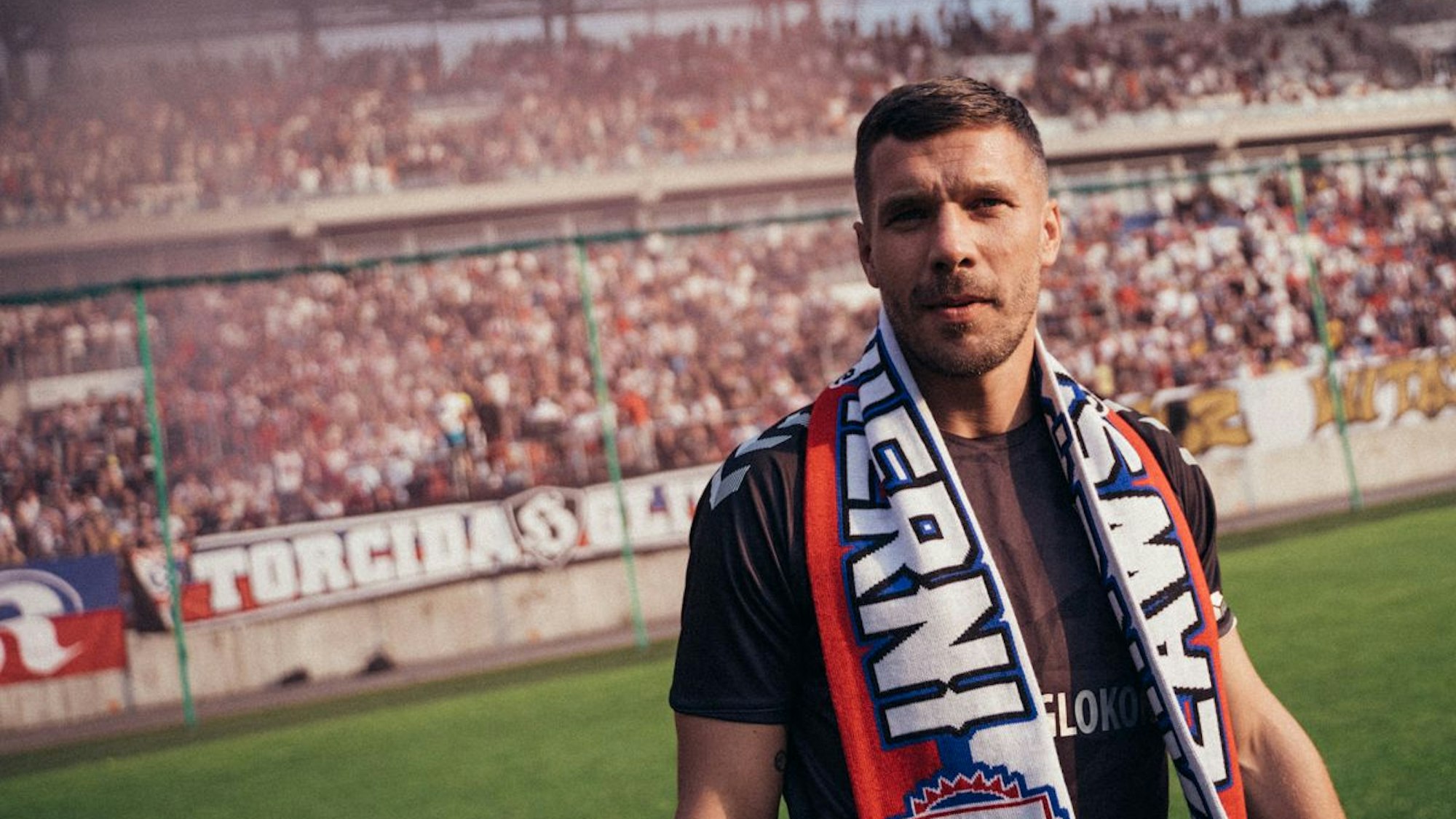 Lukas Podolski mit Fan-Schal im Stadion seines Heimatvereins Gornik Zabrze