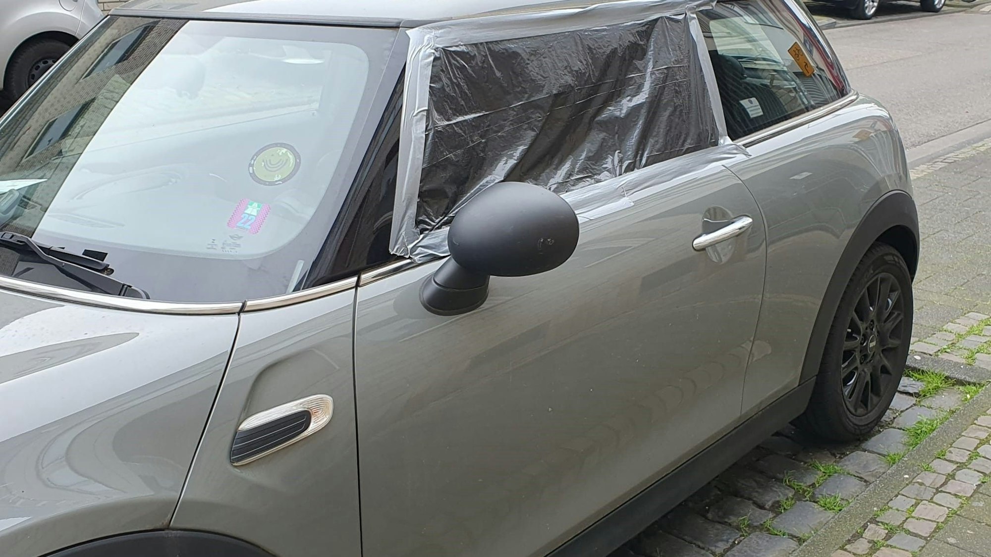 Ein Auto mit abgeklebter Fensterscheibe auf der Fahrerseite.