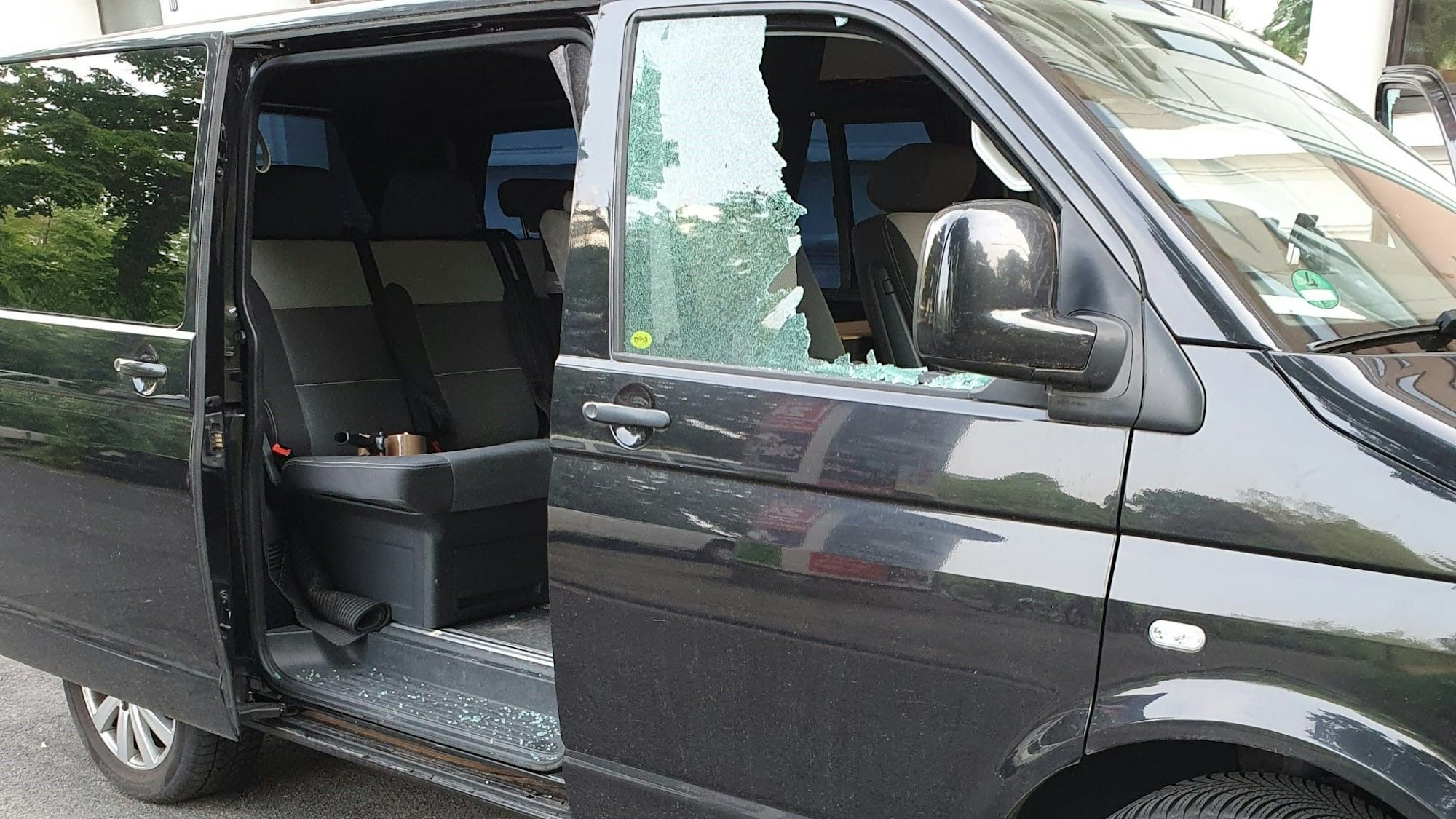 Ein VW-Bus von der Seite mit offener Tür und eingeschlagener Scheibe.