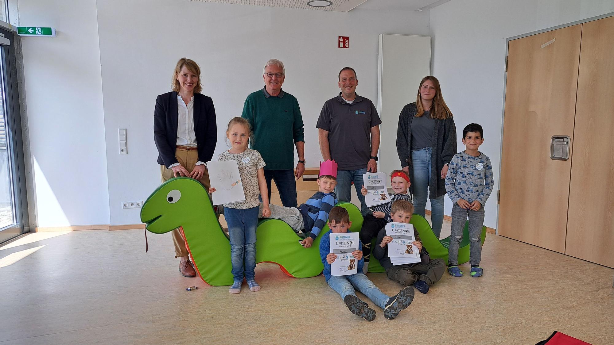 Es sind die Kinder mit ihren Urkunden zu sehen. Vier Erwachsene stehen hinter ihnen.