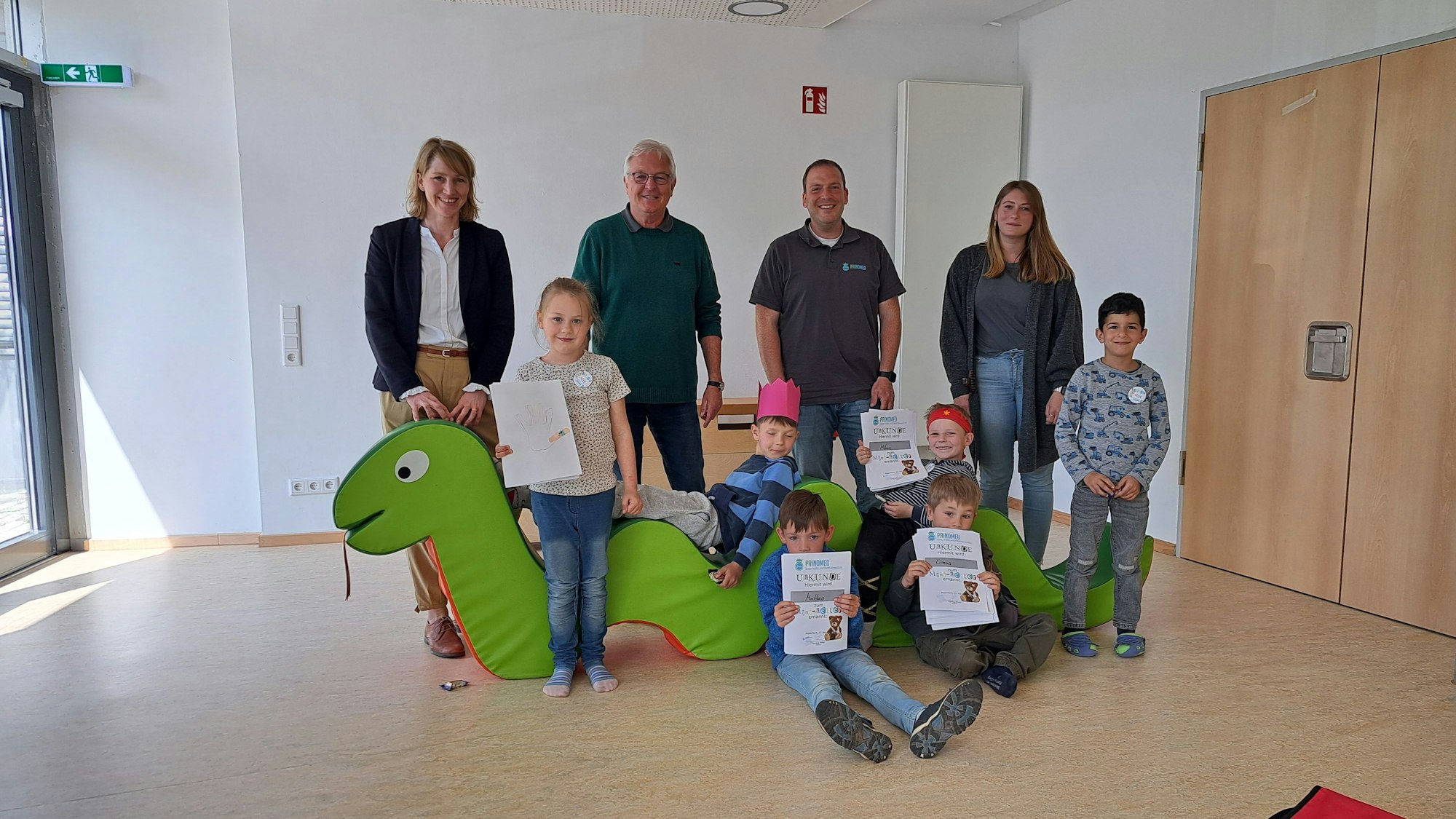 Es sind die Kinder mit ihren Urkunden zu sehen. Vier Erwachsene stehen hinter ihnen.