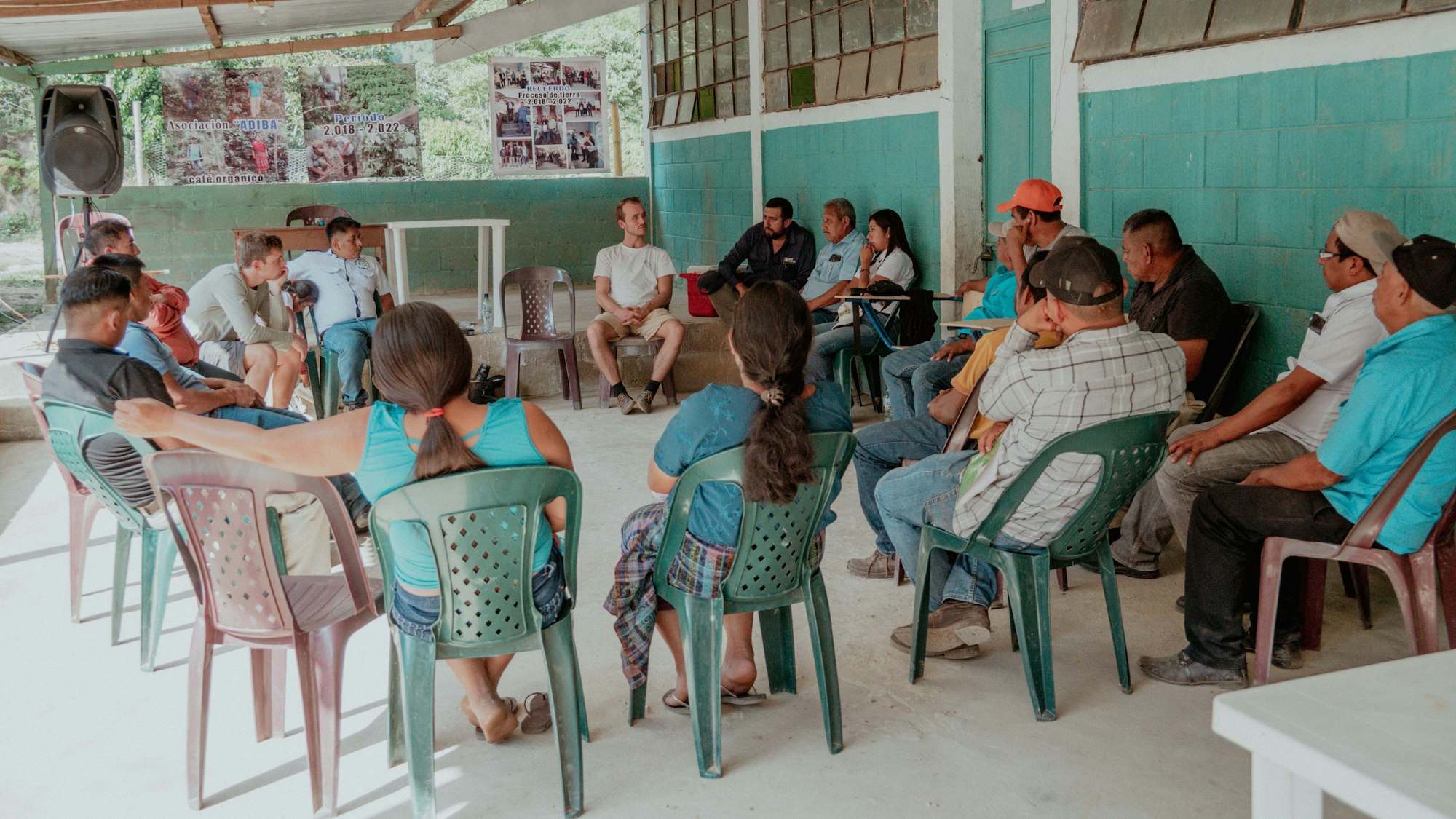 Tilman Böing und Frederik Baumann von Zwoo Kaffeeröster aus Köln sitzen im Stuhlkreis mit Kaffeebauern aus der Kooperative Adiba in Guatemala.
