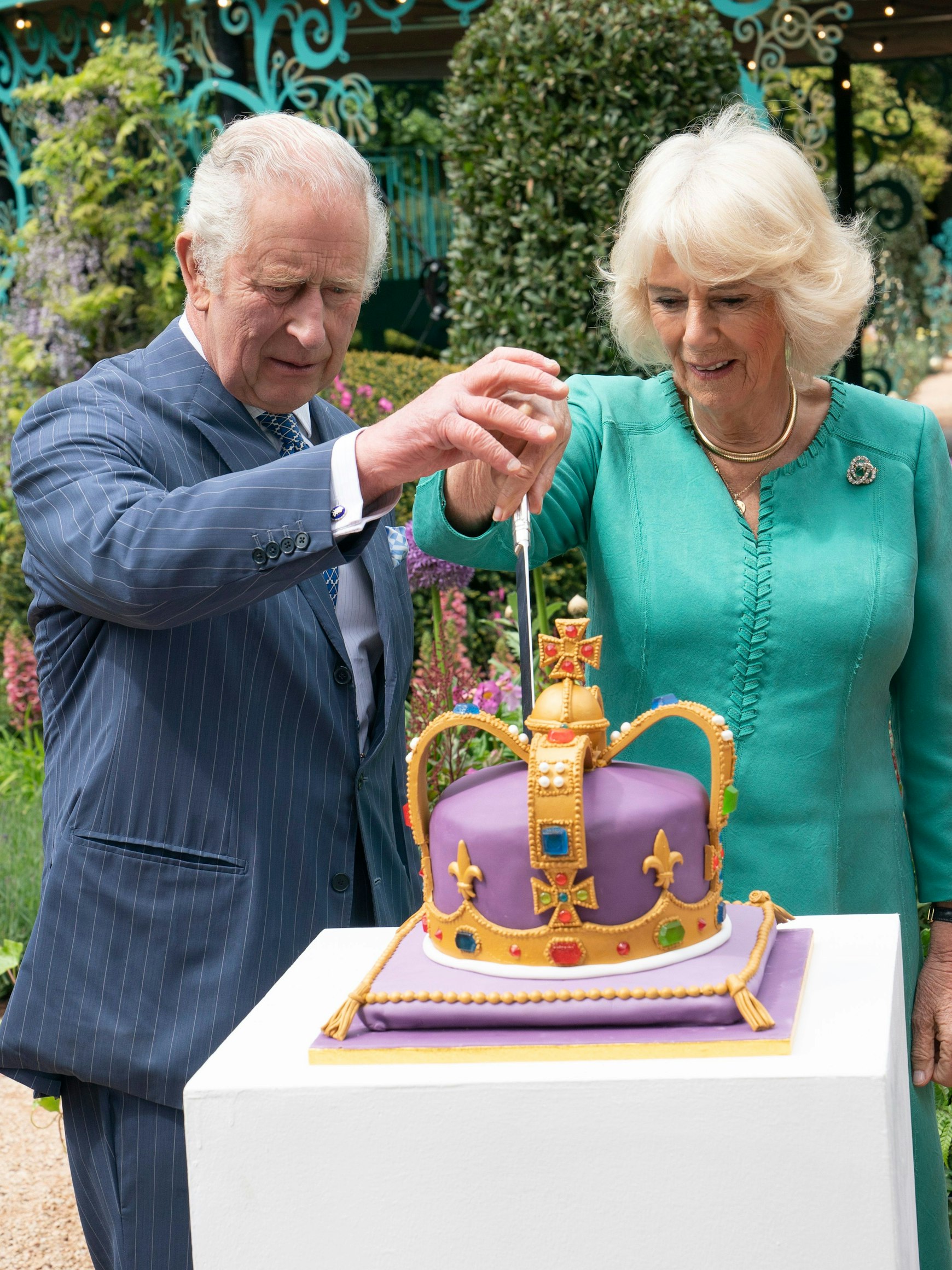 König Charles III. und Königin Camilla schneiden eine Torte an, um den neuen Coronation Garden zu eröffnen.