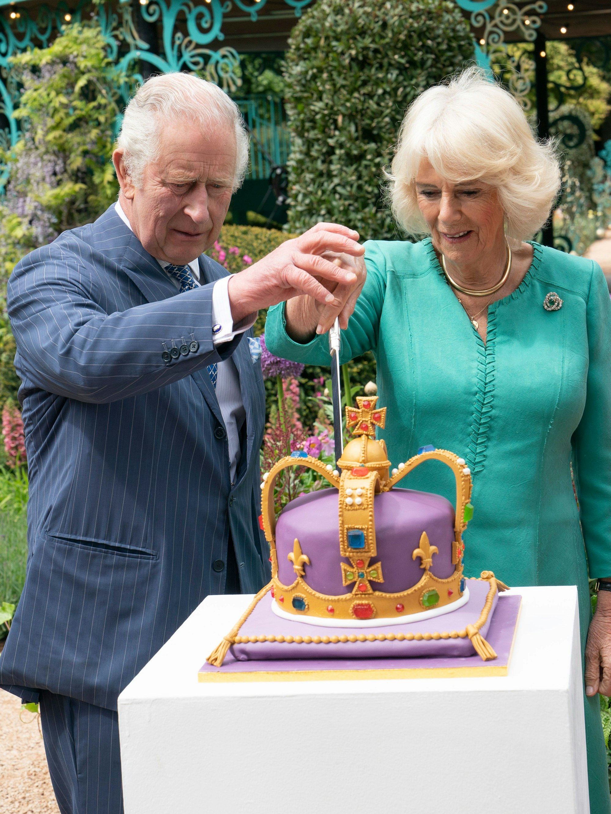 König Charles III. und Königin Camilla schneiden eine Torte an, um den neuen Coronation Garden zu eröffnen.