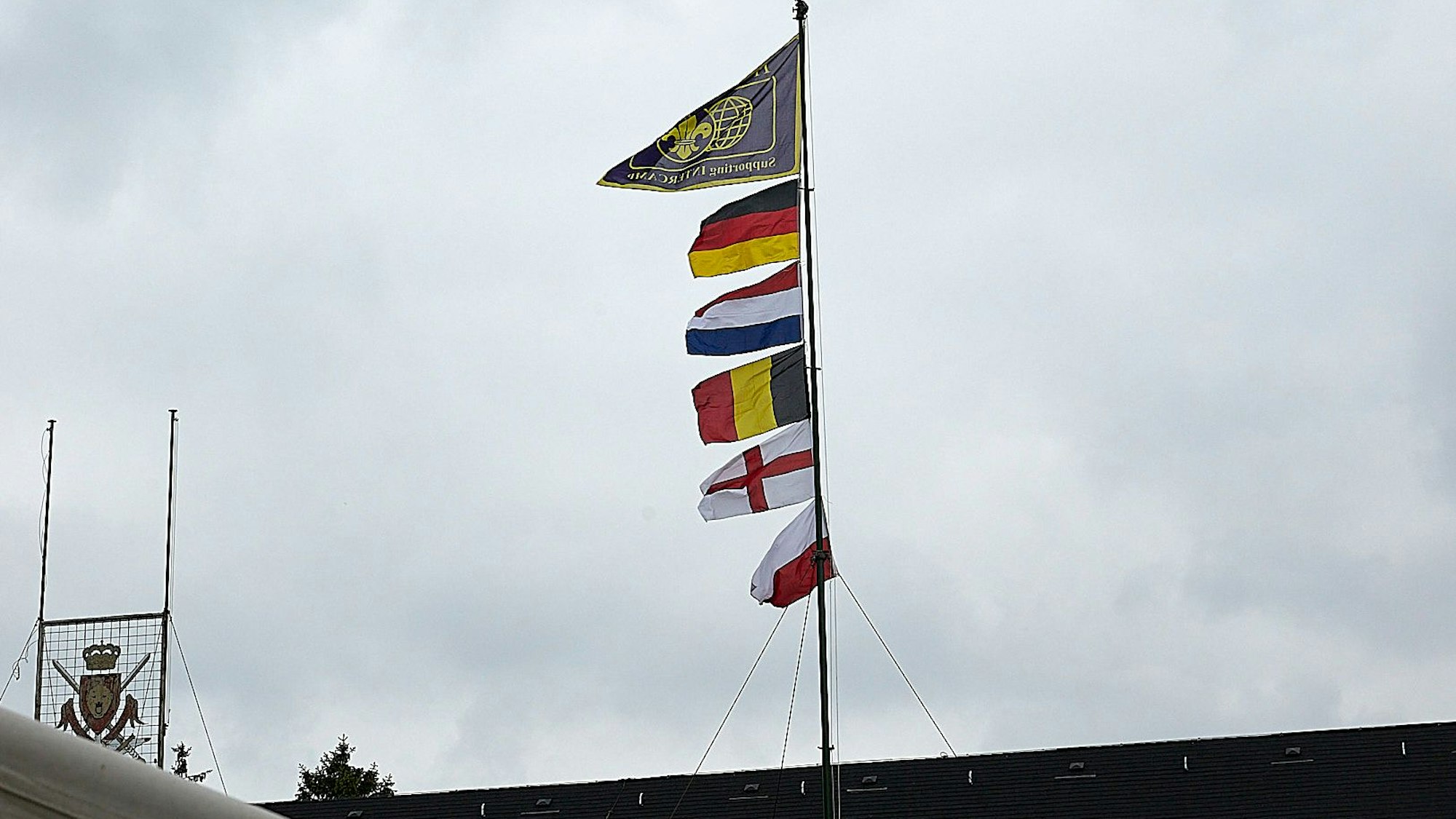 Sechs Fahnen sind an einem Mast befestigt.