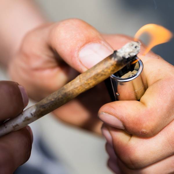 Ein Mann zündet einen Joint mit Medizinalcannabis an.