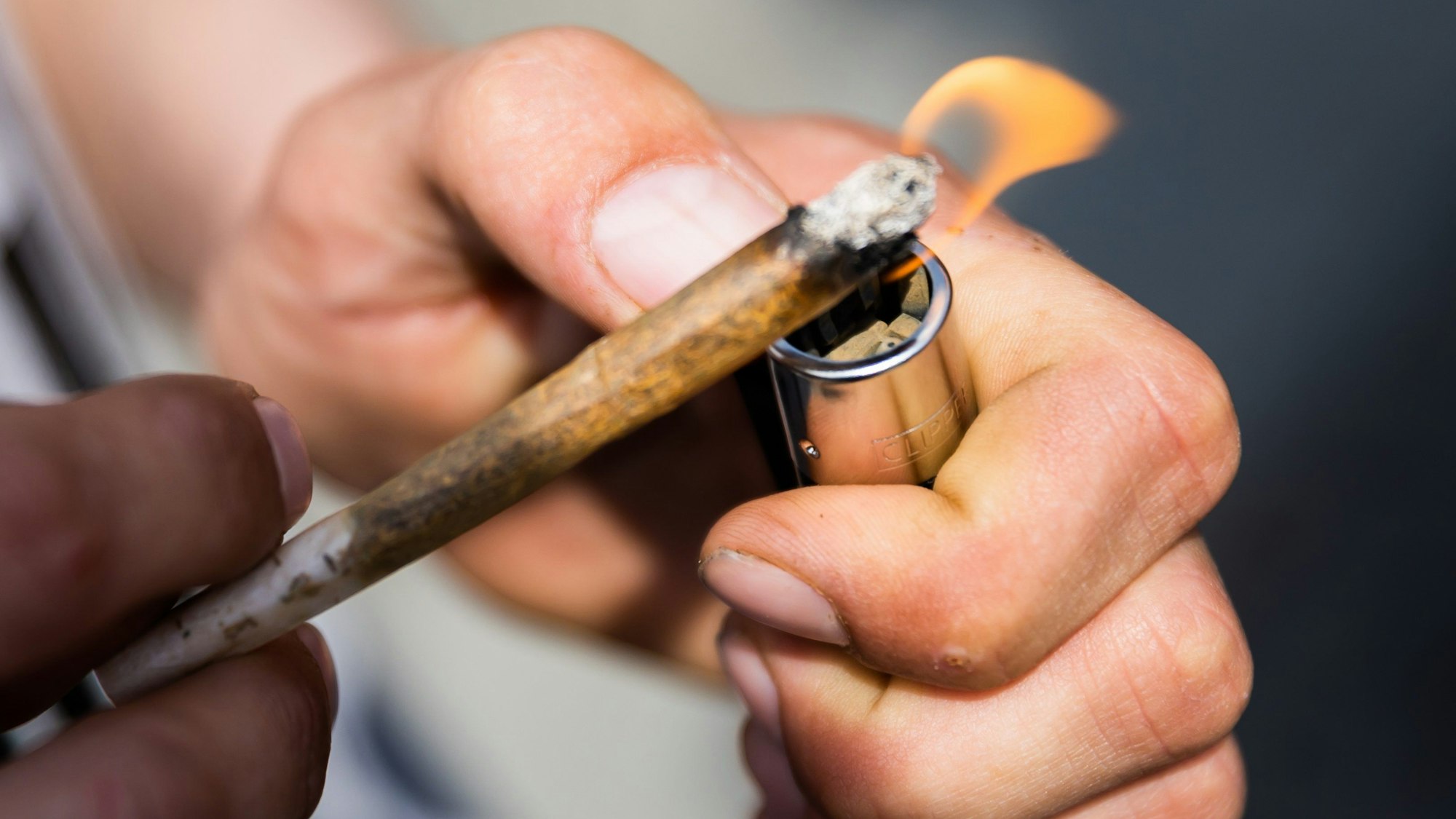 Ein Mann zündet bei der Auftaktkundgebung einer Demonstration für eine zügige Legalisierung von Cannabis, dem «Global Marijuana March 2022», am Brandenburger Tor einen Joint mit Medizinalcannabis an. Ab Donnerstag 25. Mai gilt im alten Zentrum der niederländischen Hauptstadt ein Kiff-Verbot. Es ist eine neue Maßnahme gegen Probleme durch Über-Tourismus