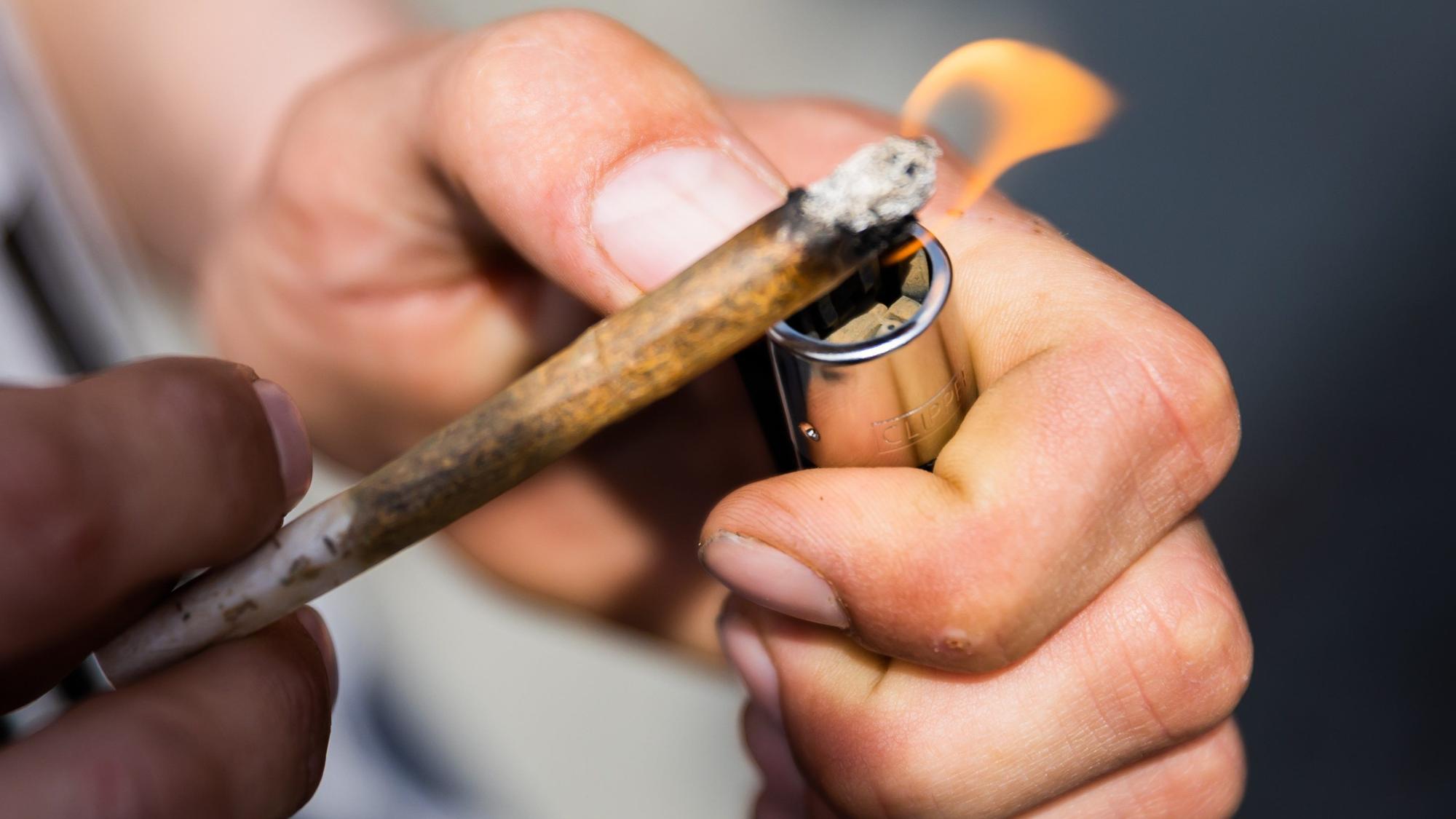 Ein Mann zündet einen Joint an. Für die Legalisierung von Cannabis werden auch Modellregionen und Modellstädte diskutiert, in denen der freie Verkauf von Marihuana getestet werden soll. (Symbolbild)