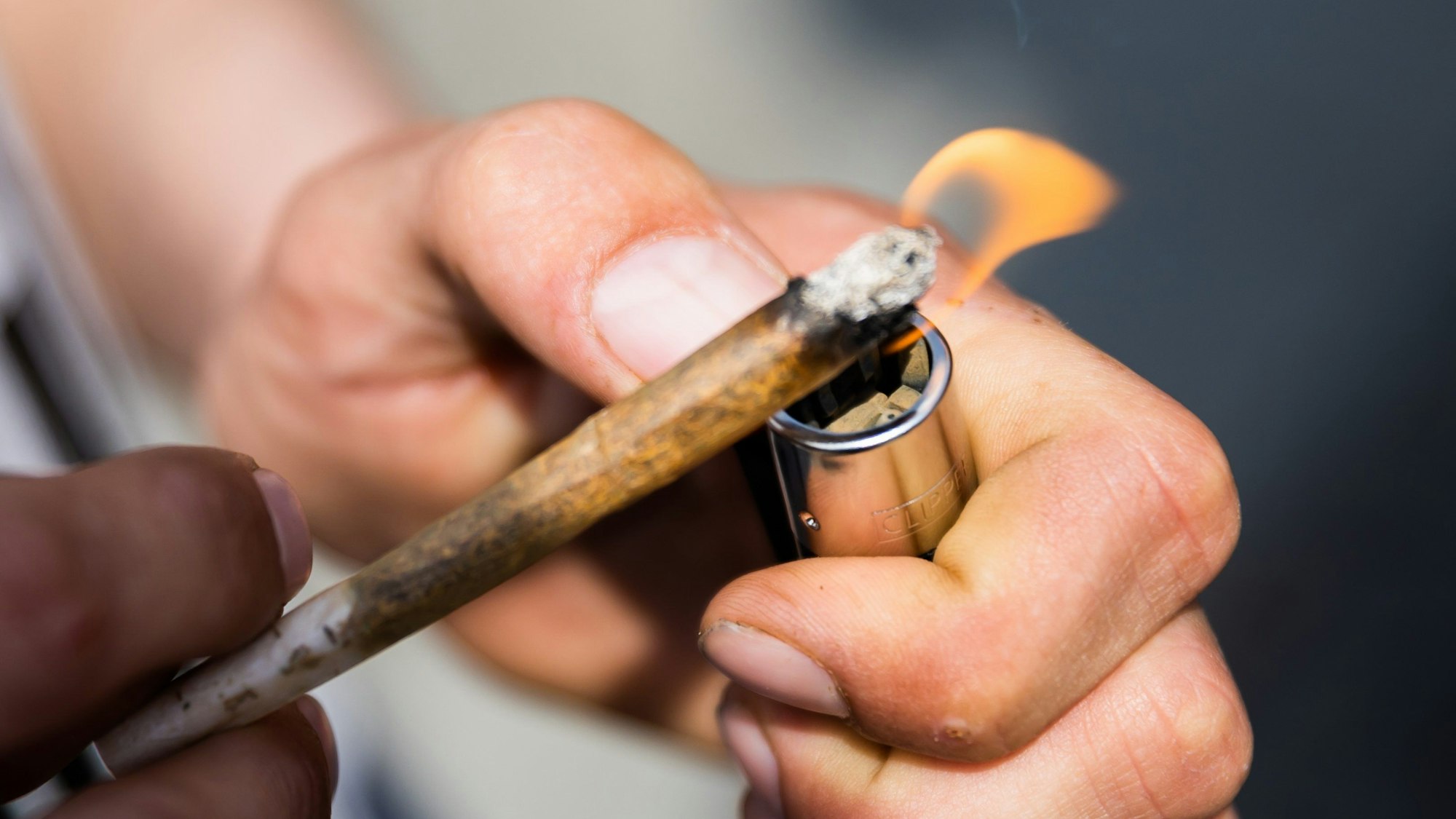 Ein Mann zündet einen Joint mit Medizinalcannabis an.