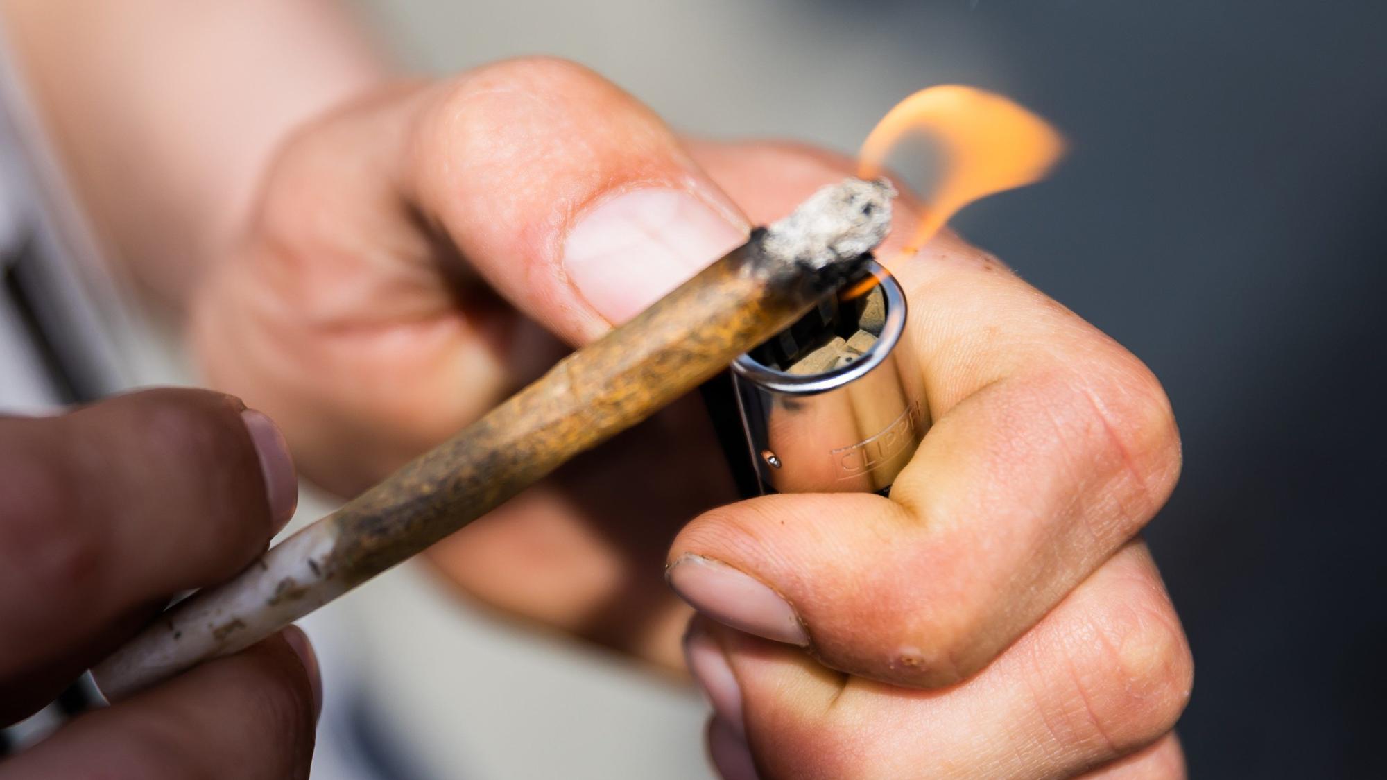 Ein Mann zündet einen Joint an.