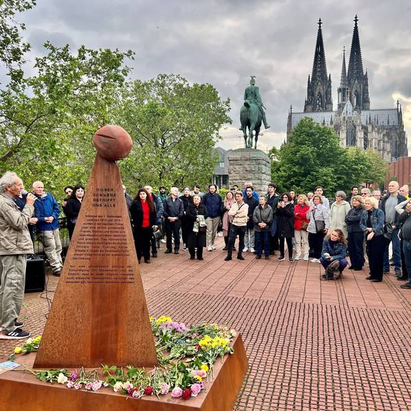Kundgebung vor einem Mahnmal für den Genozid an Armeniern, im Hintergrund das Reiterdenkmal und der Kölner Dom.