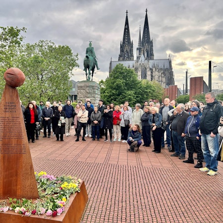 Kundgebung vor einem Mahnmal für den Genozid an Armeniern, im Hintergrund das Reiterdenkmal und der Kölner Dom.