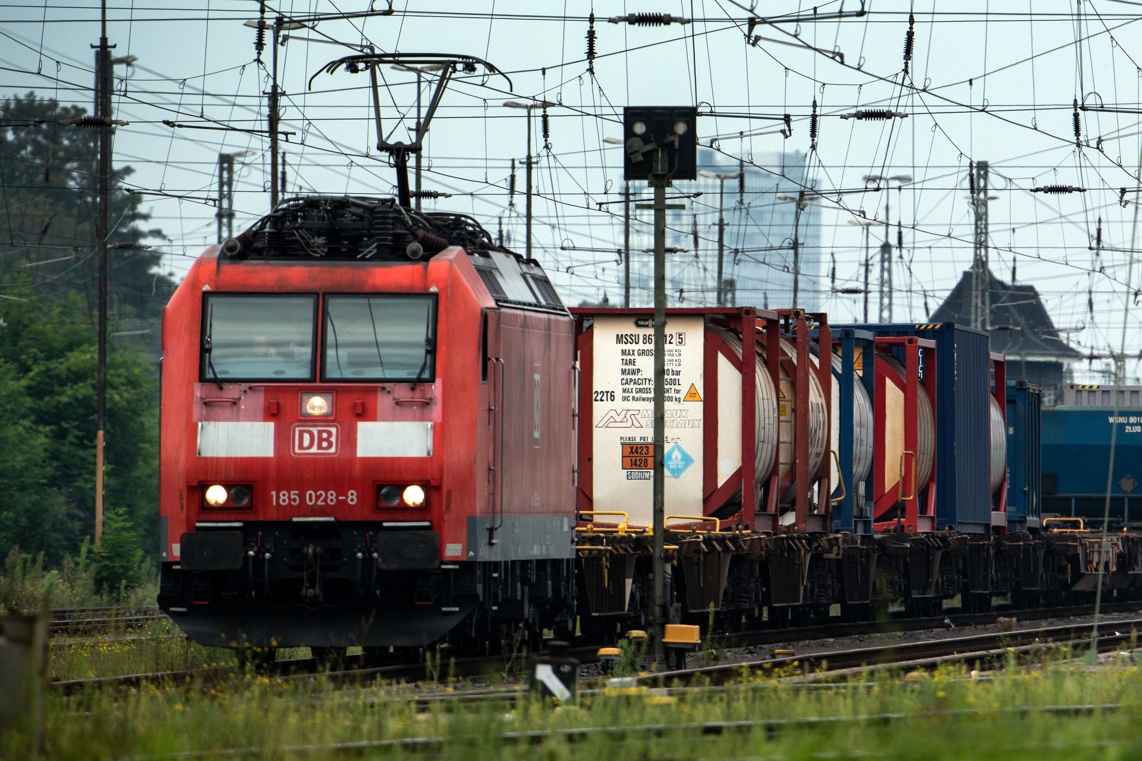 Eine Lok zieht einen Güterzug unter einem Gewirr aus Oberleitungen und Signalen. (Symbolbild)