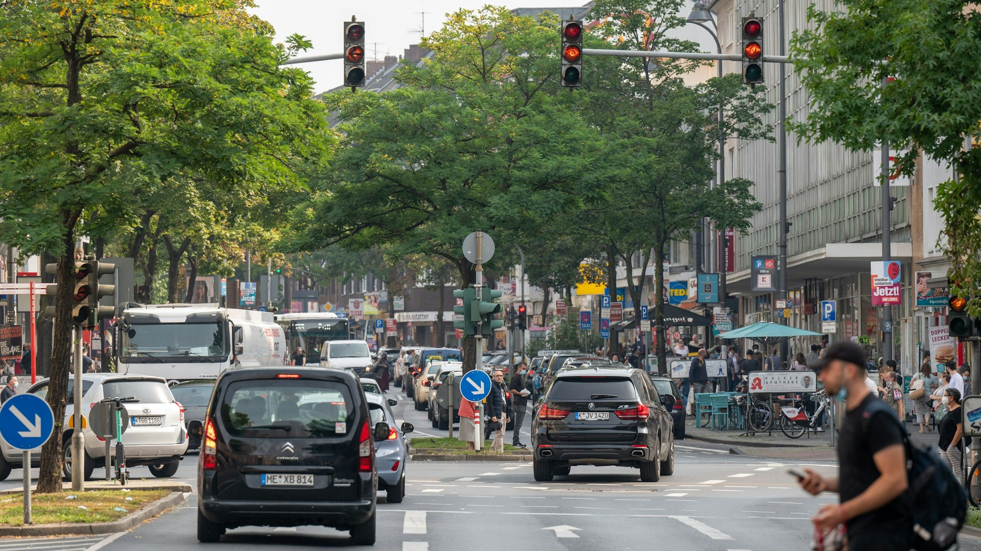 Fußgänger und Autofahrer an einer Ampelkreuzung