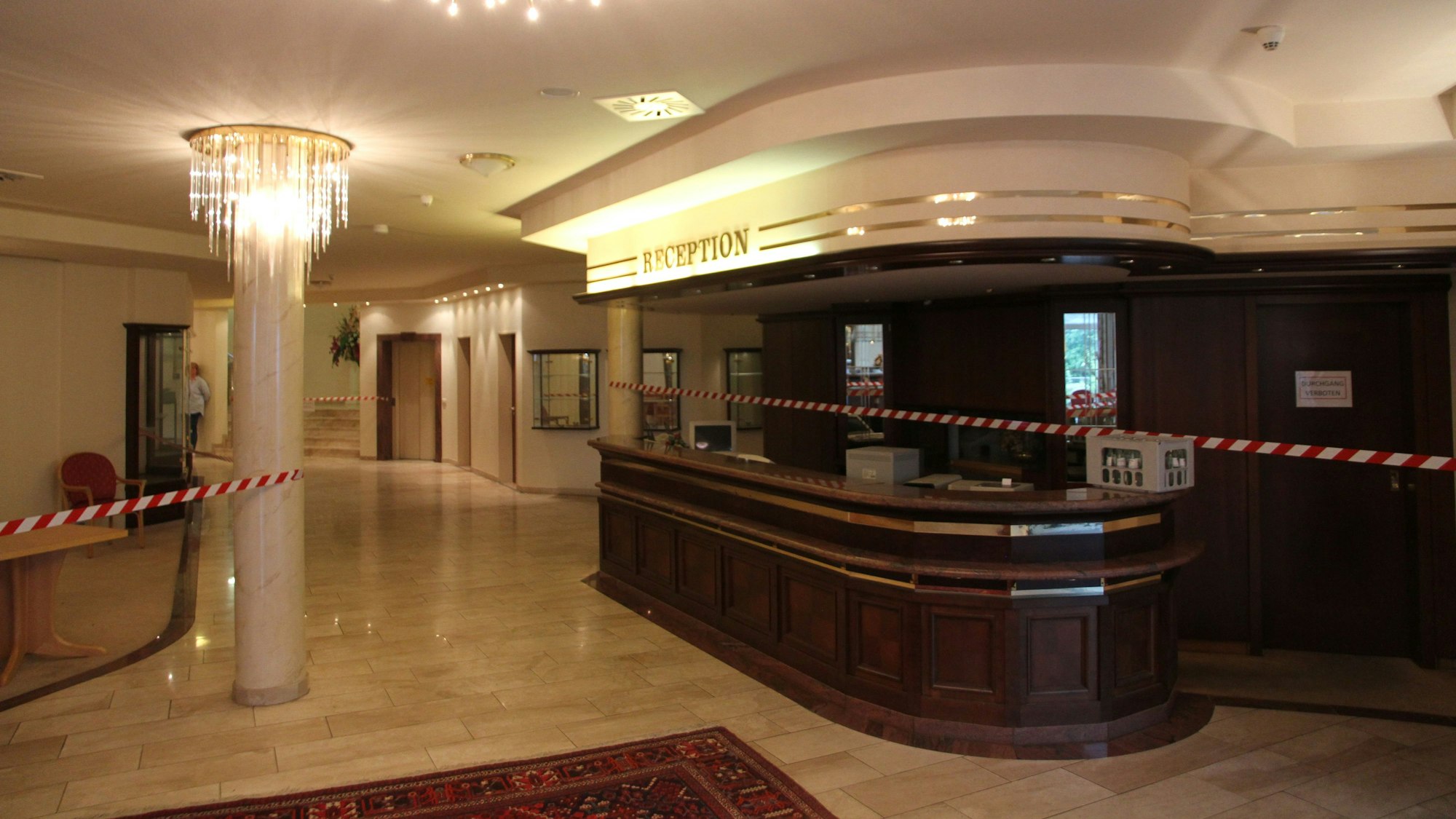 Ein Hotelfoyer mit Rezeptionstheke aus dunklem Holz