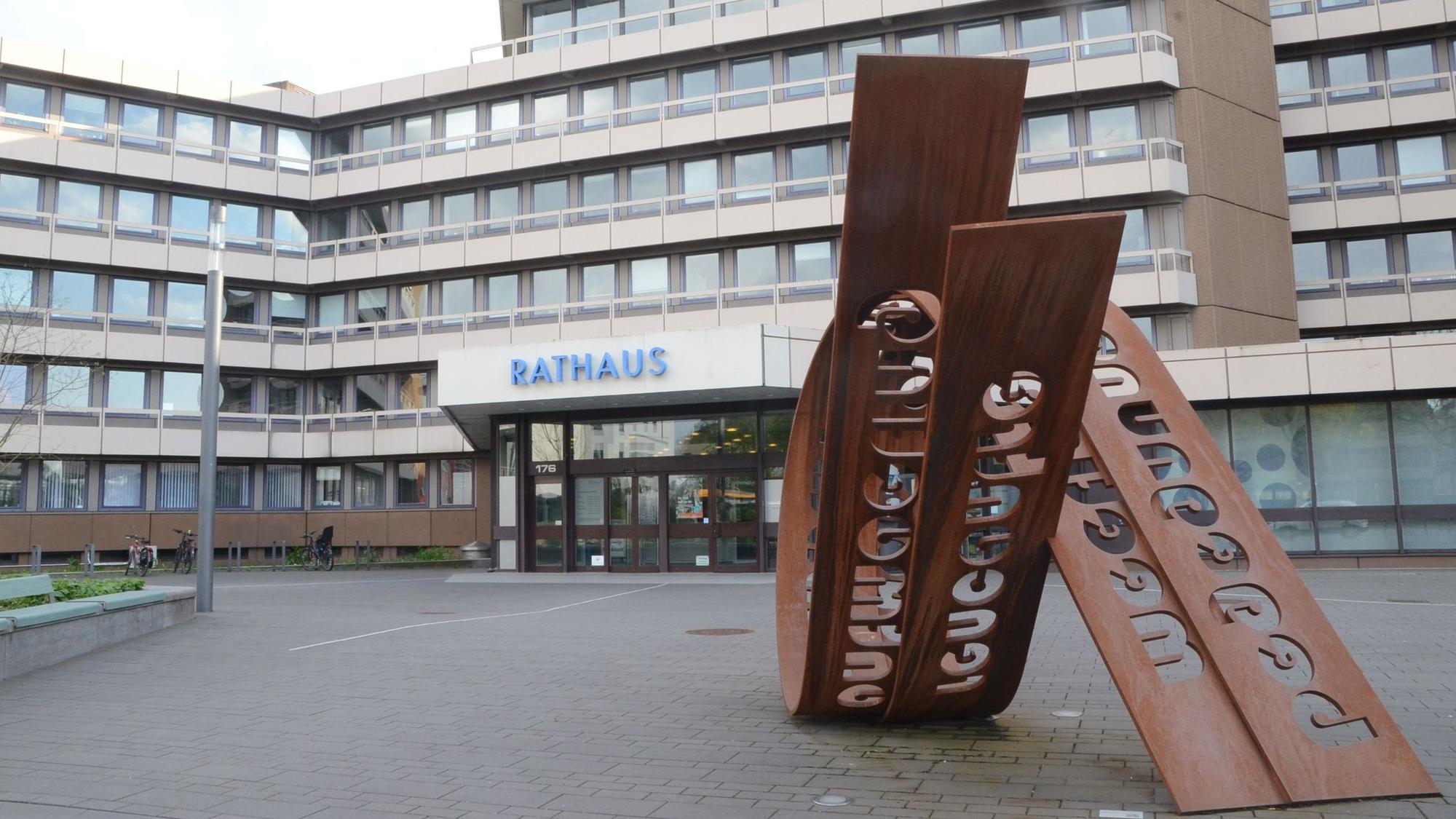 Das Rathaus in Troisdorf, in blauen Buchstaben hängt die Aufschrifft "Rathaus" am Eingang des Gebäudes.