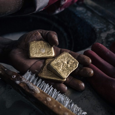 In einer Hand liegt Gold, das mit einer Bürste gereinigt wird. (Symbolbild)