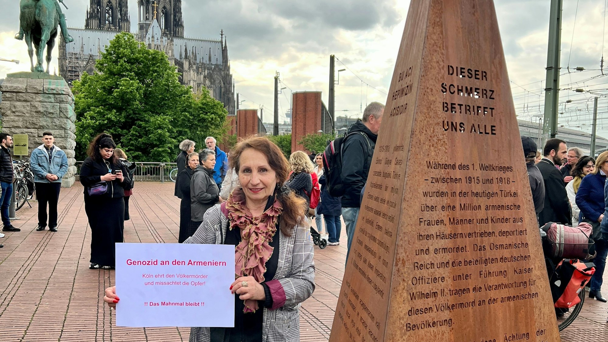 Eine Demonstrantin steht vor einer Erinnerungsstele an den Völkermord an Armeniern im Osmanischen Reich.