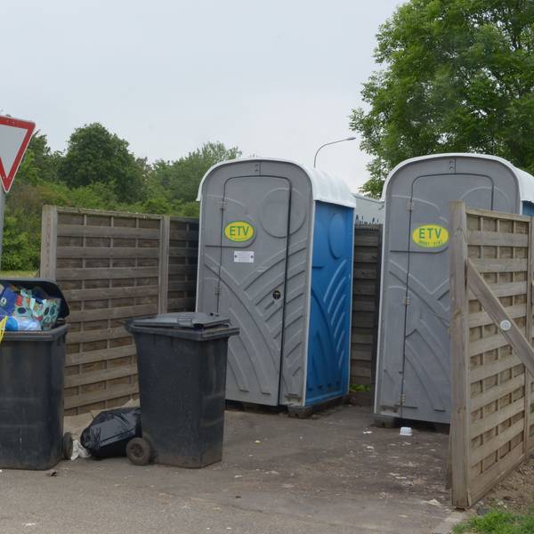 Das Bild zeigt zwei volle Mülltonnen und zwei mobile Toiletten im Euskirchener Industriepark.