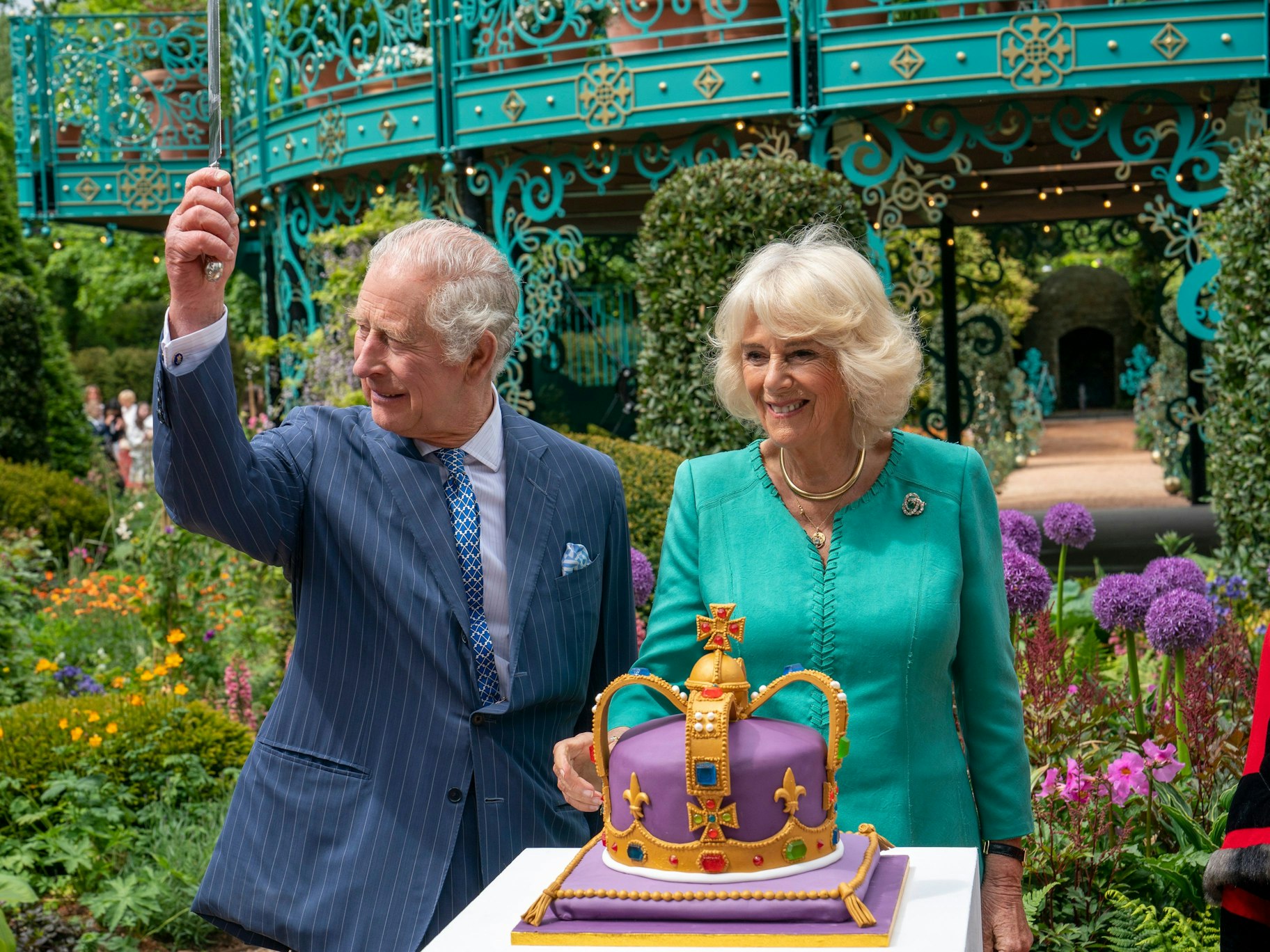 König Charles III. und Königin Camilla schneiden eine Torte an, um den neuen Coronation Garden zu eröffnen.