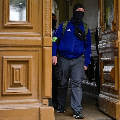 Ein Polizist in einem Gebäude in Berlin-Kreuzberg. Gegen die „Letzte Generation“ hat es eine Razzia gegeben.