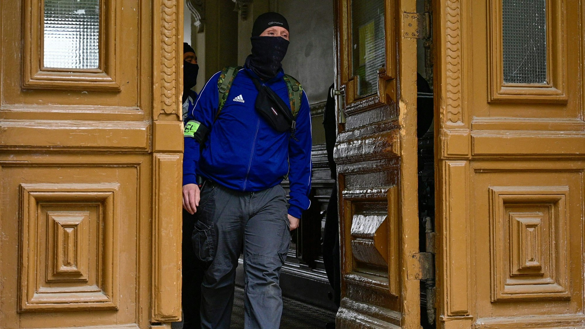 Ein Polizist in einem Gebäude in Berlin-Kreuzberg. Gegen die „Letzte Generation“ hat es eine Razzia gegeben.