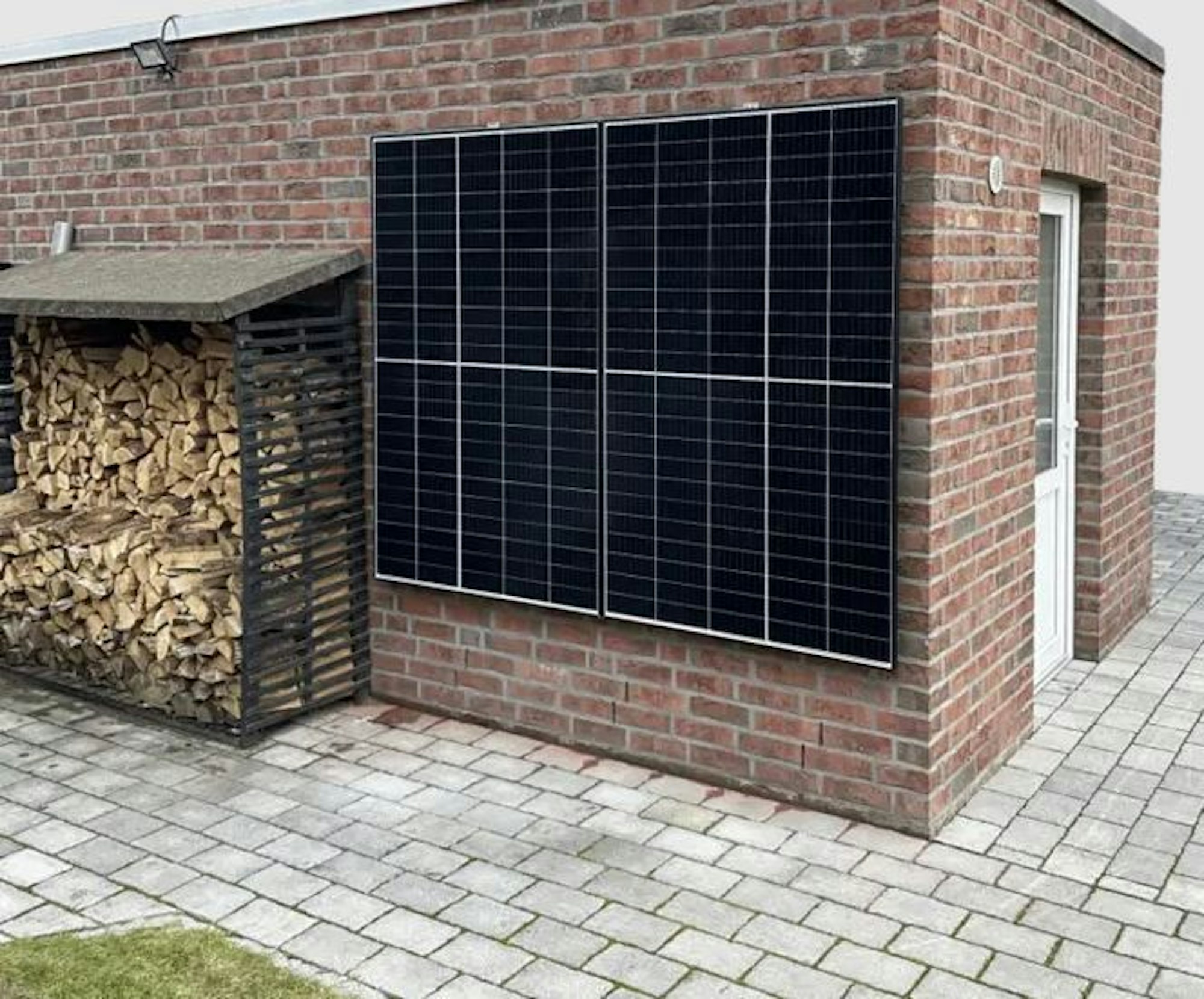Zwei Solarmodule als Balkonkraftwerk an einer Hauswand angebracht.