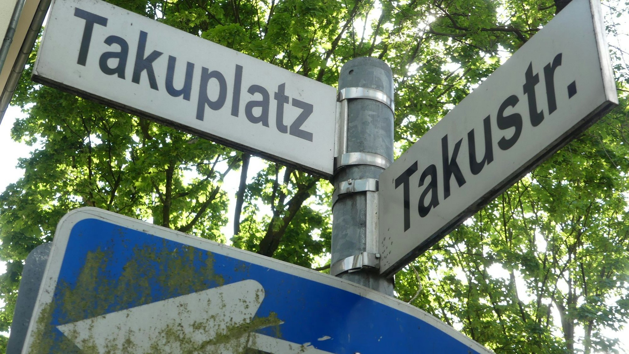 Zwei Straßenschilder hängen an einem Mast.