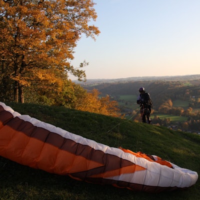 Ein Paraglider landet auf einem Hügel.