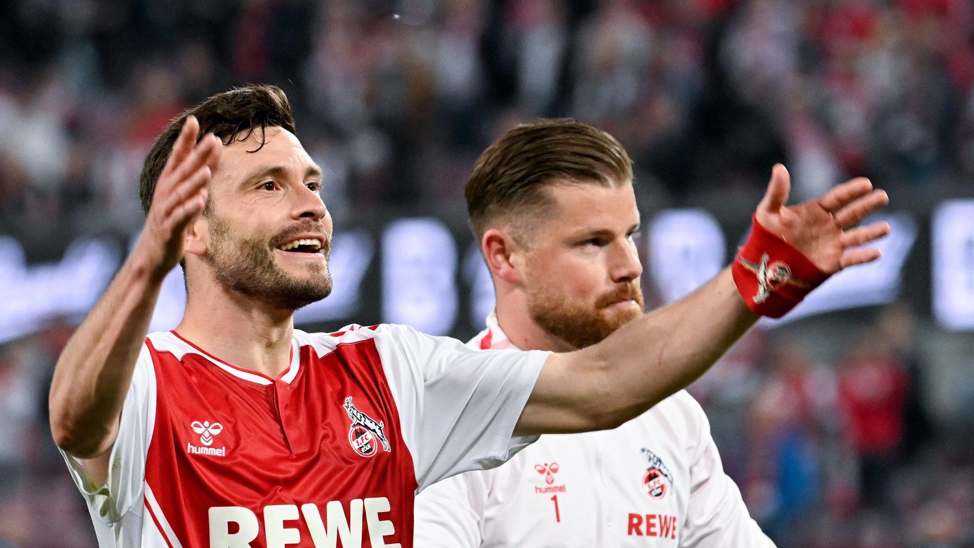 Kölns Jonas Hector (l) und Torhüter Timo Horn jubeln nach dem Spiel vor den Fans.