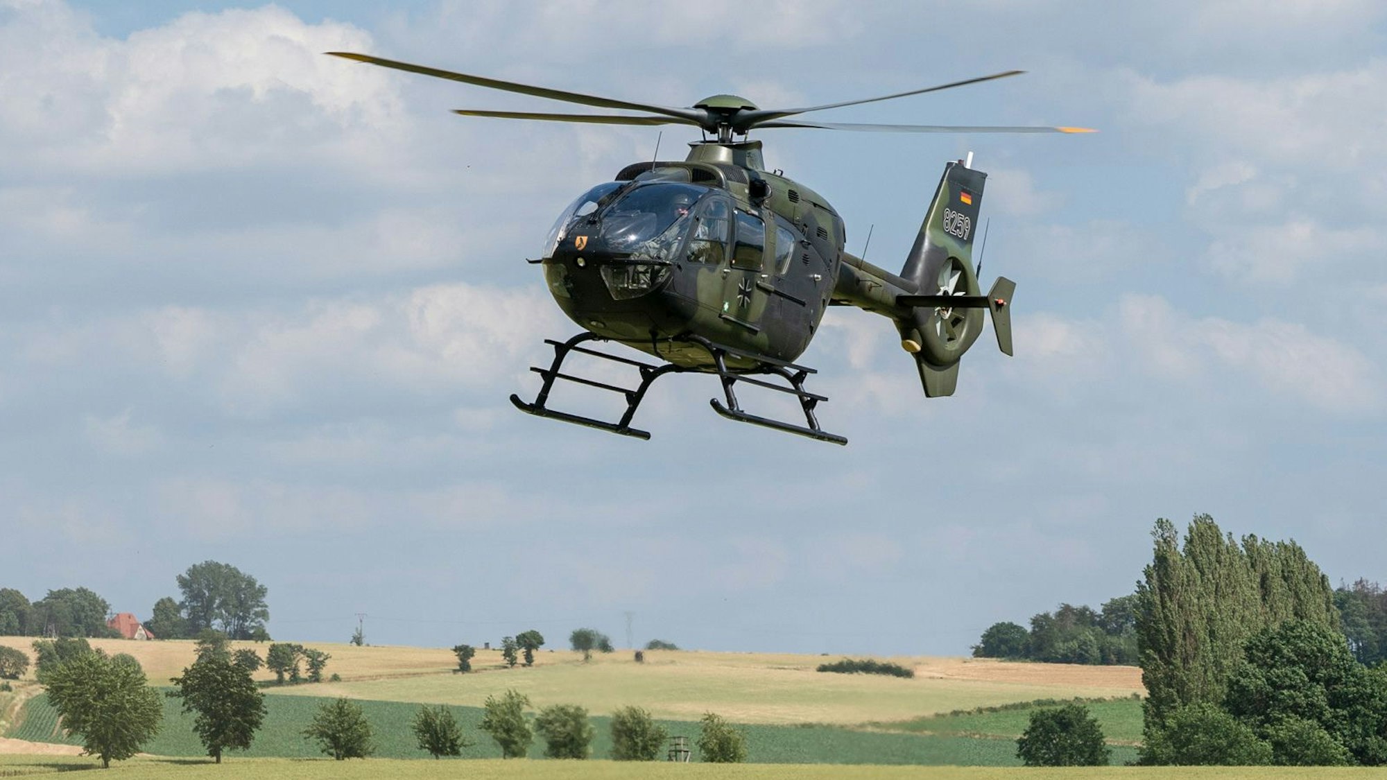 Ein Hubschrauber der Bundeswehr vom Typ Eurocopter EC-135 fliegt über ein Feld. (Symbolbild)