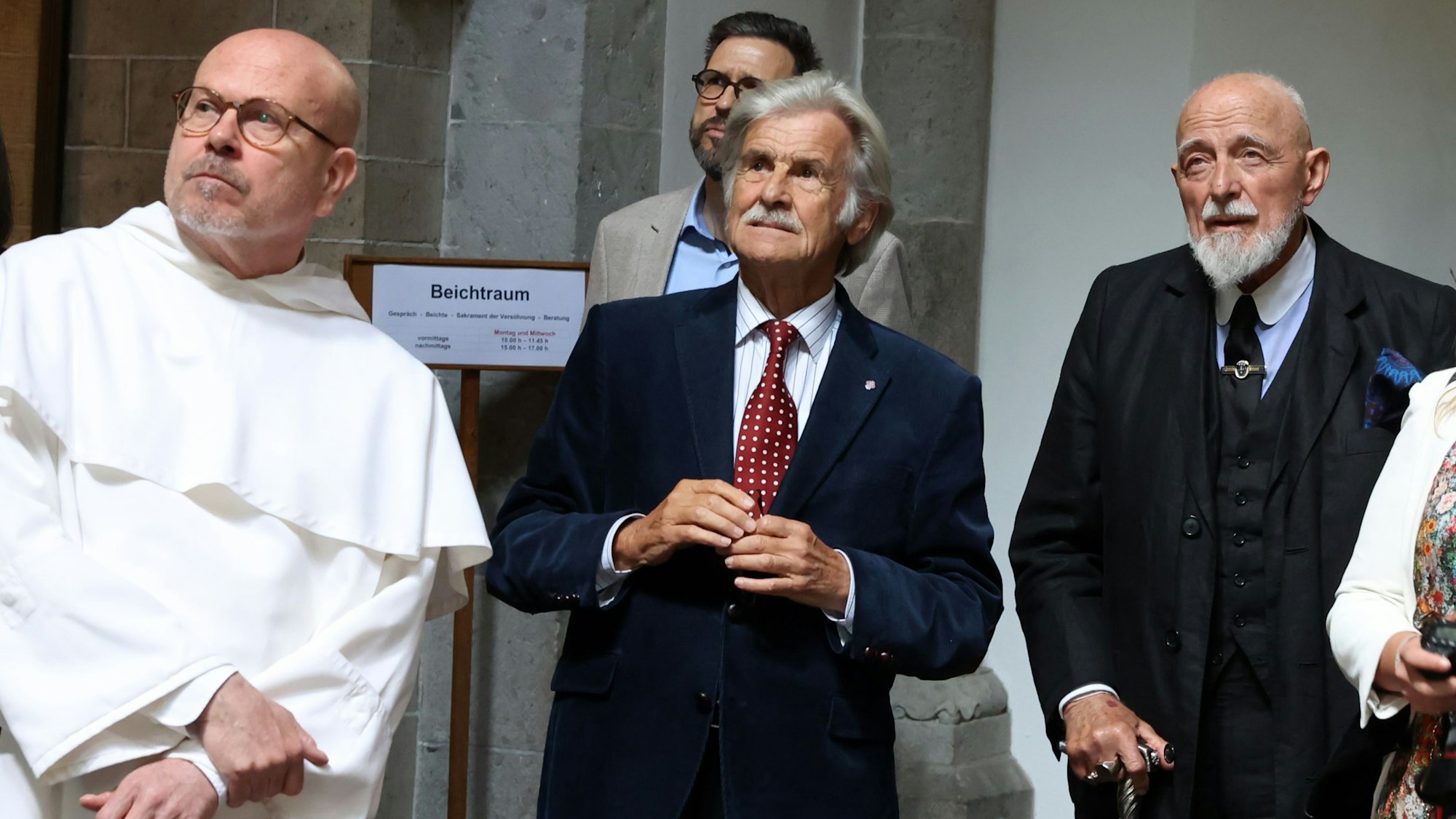 Drei Männer schauen zum Bild heraus und betrachten ein Kirchenfenster des Künstlers Markus Lüpertz.